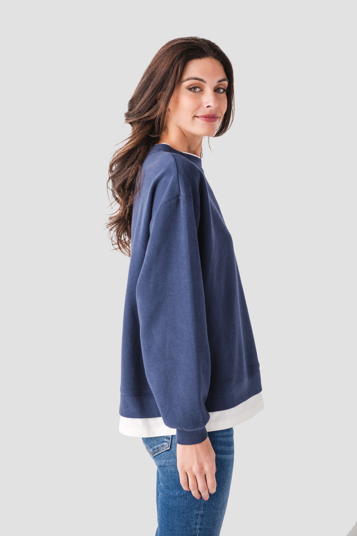 Blue crewneck pullover with ribbed hem and cuffs, relaxed fit, side view with white trim