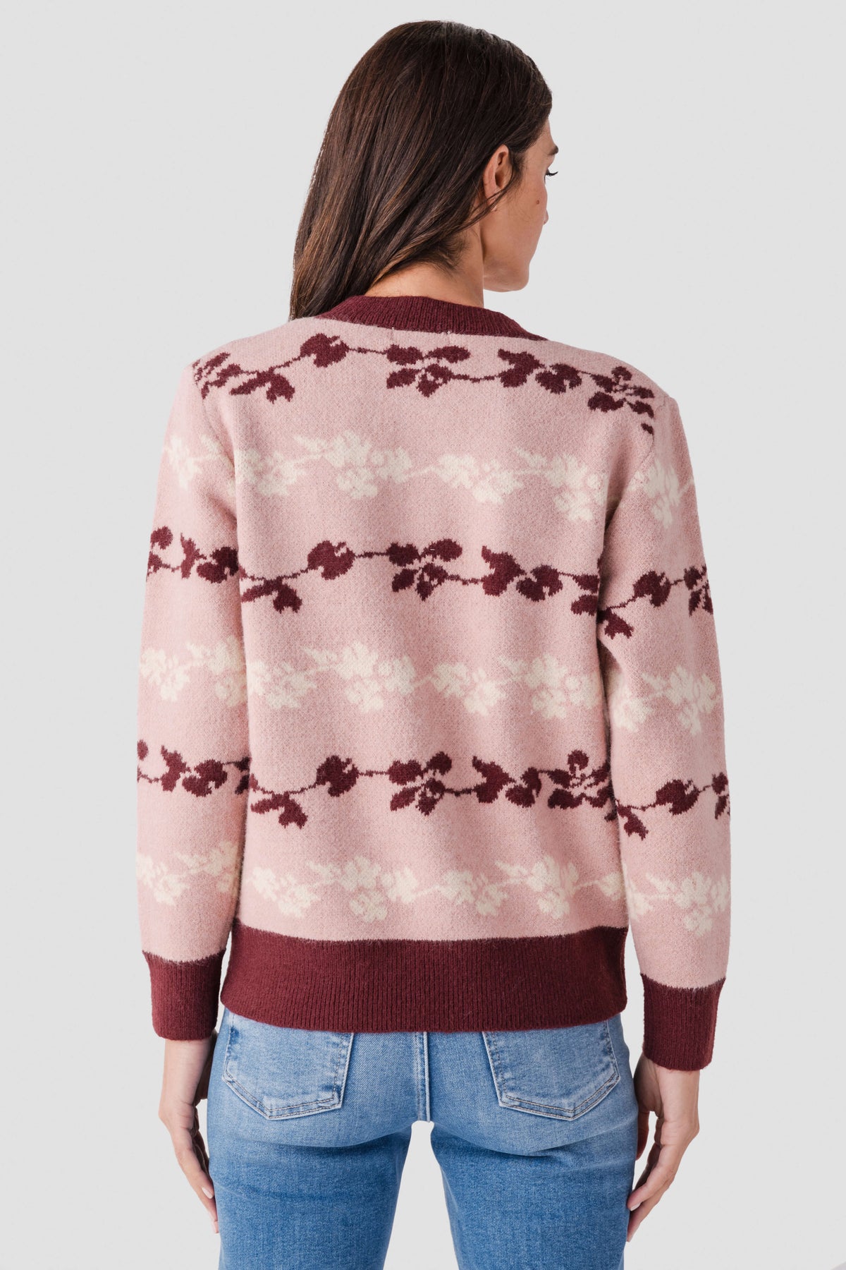 Back view of floral jacquard knit pullover in mute rose with maroon bow stripe pattern