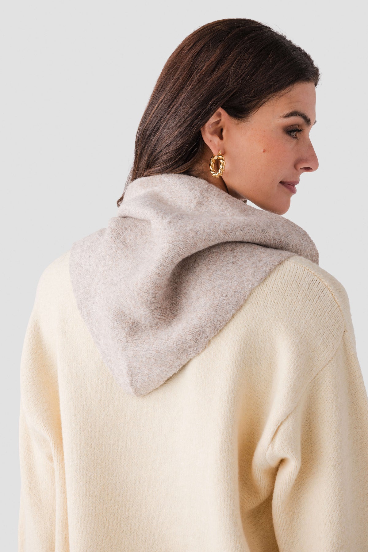 Cream wool triangle scarf draped over shoulders, side view