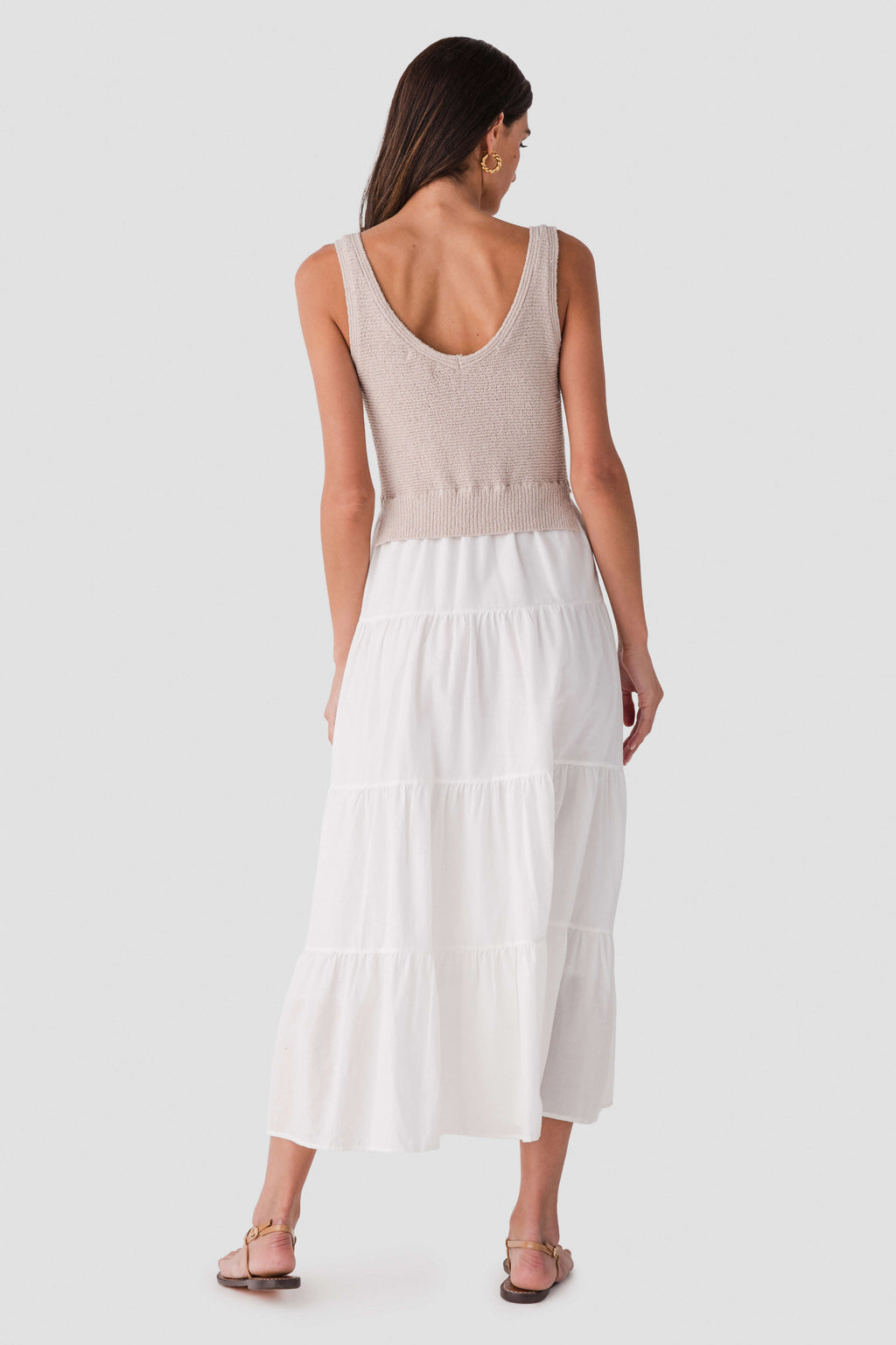 Back view of light sleeveless maxi dress with scoop back and tiered skirt