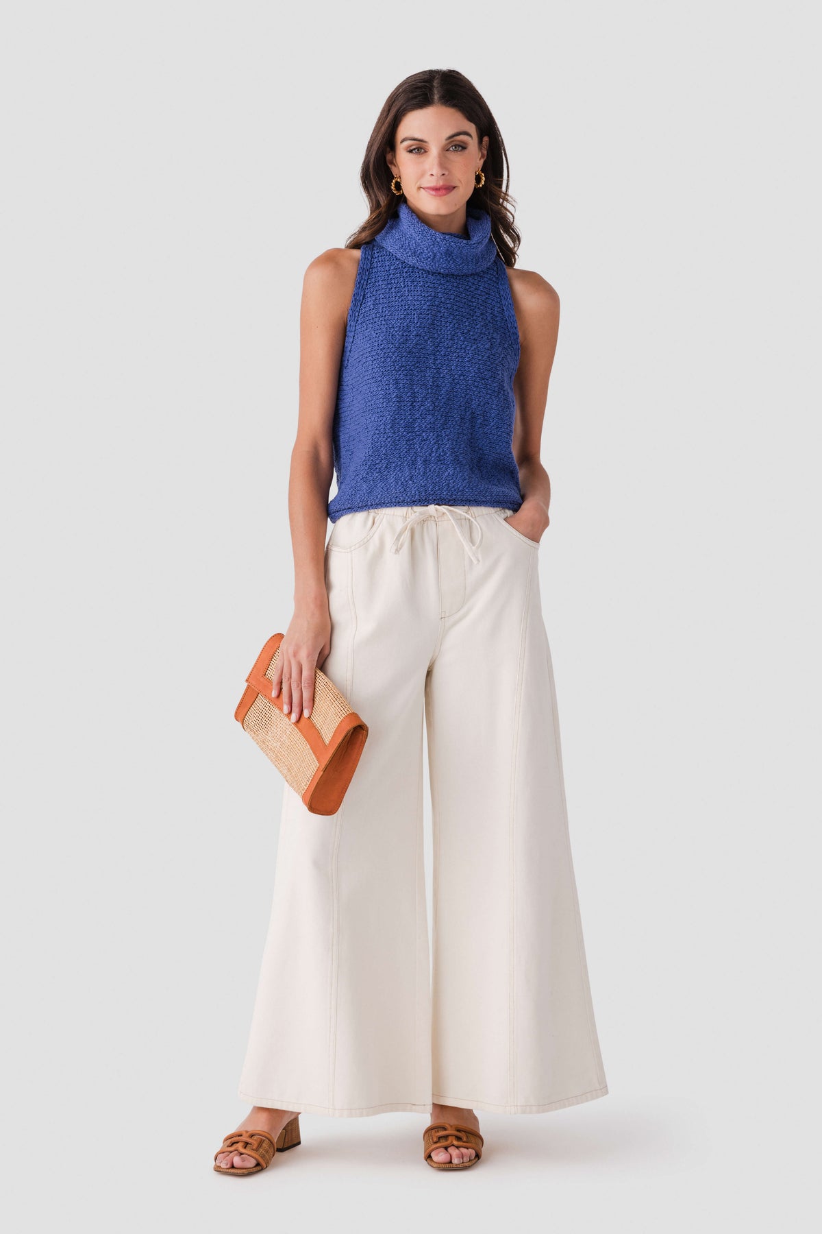 Blue sleeveless knit turtleneck top with high neckline and textured fabric