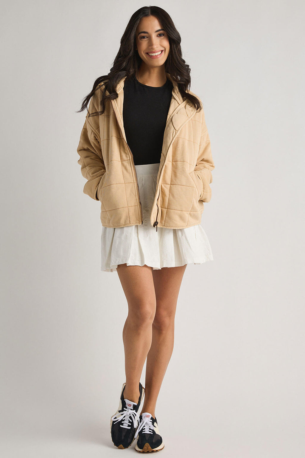 White pleated tennis-style skirt with elastic waistband and short flared silhouette.