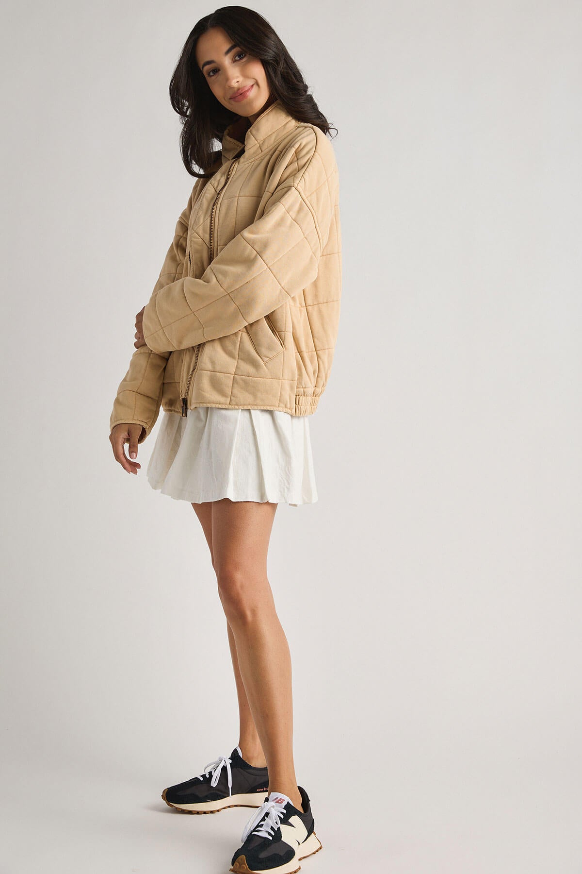 White pleated tennis-style skirt with gathered waist and slightly flared skirt hem.