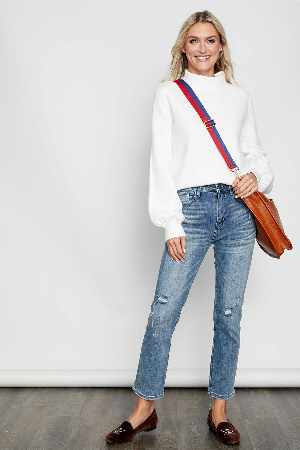 Red and navy striped shoulder strap with gold end clasps, worn crossbody