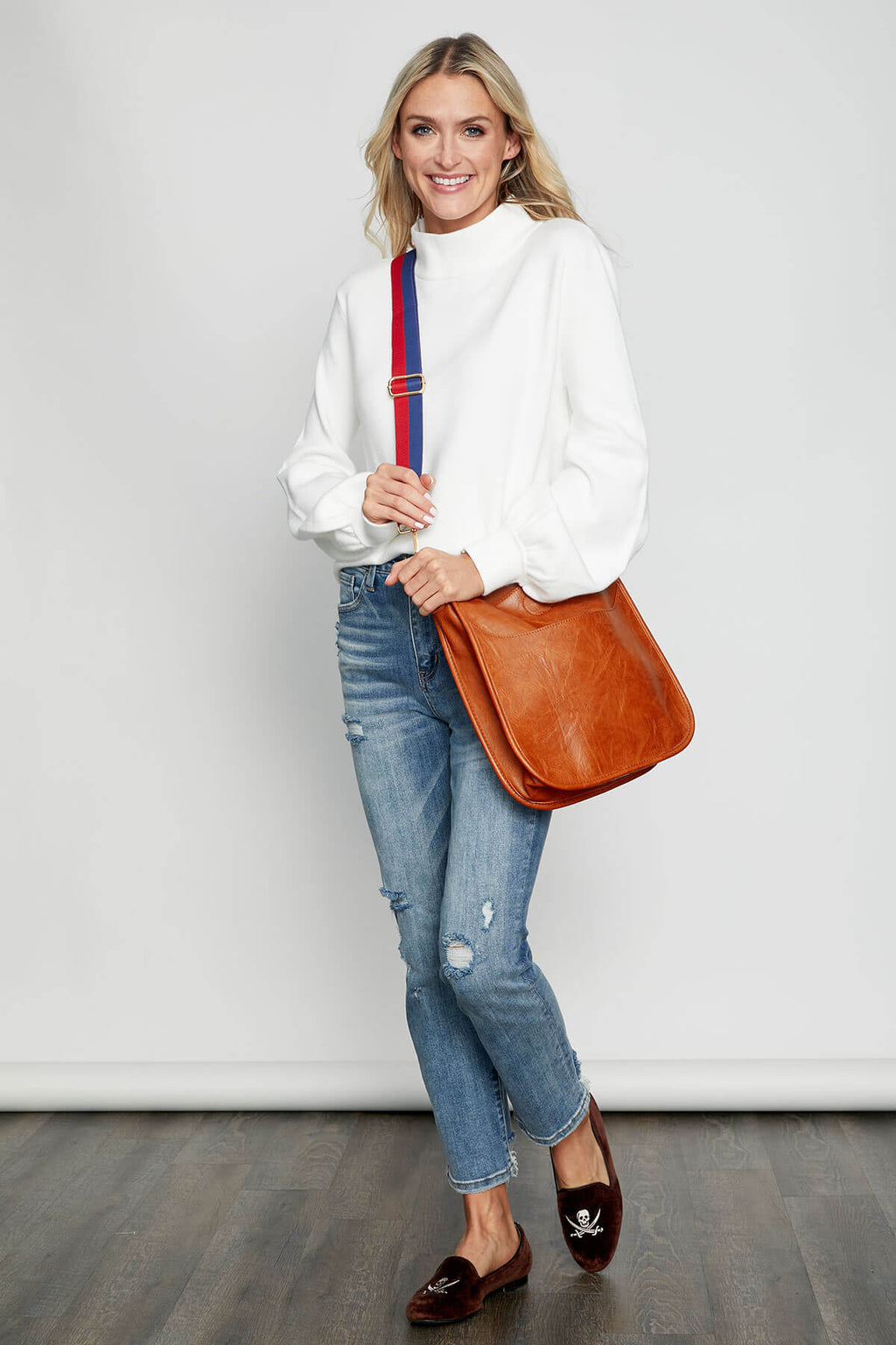 Navy and red striped bag strap with gold buckles and end clips, crossbody view