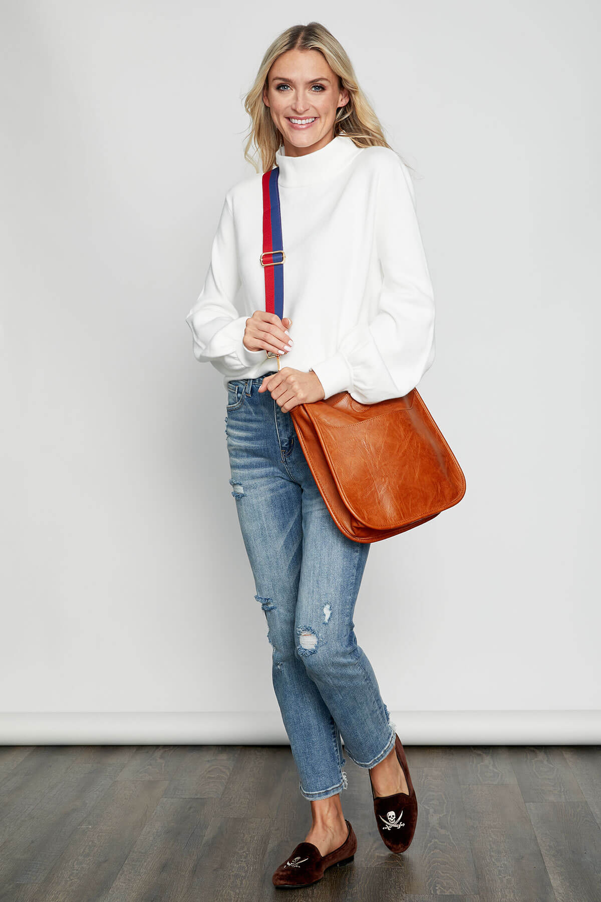 Navy and red striped bag strap with gold buckles and end clips, crossbody view